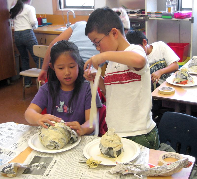 kids working together on a volcano model